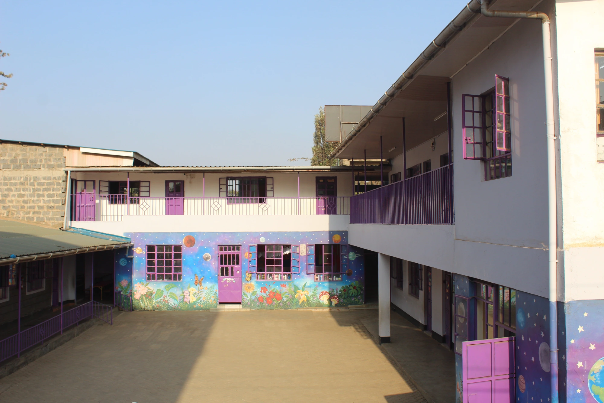 Toll Campus courtyard with purple windows and colourful classroom murals